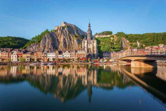 Dinant speilet i Maas, med citadellet og kirken mot klippeveggen