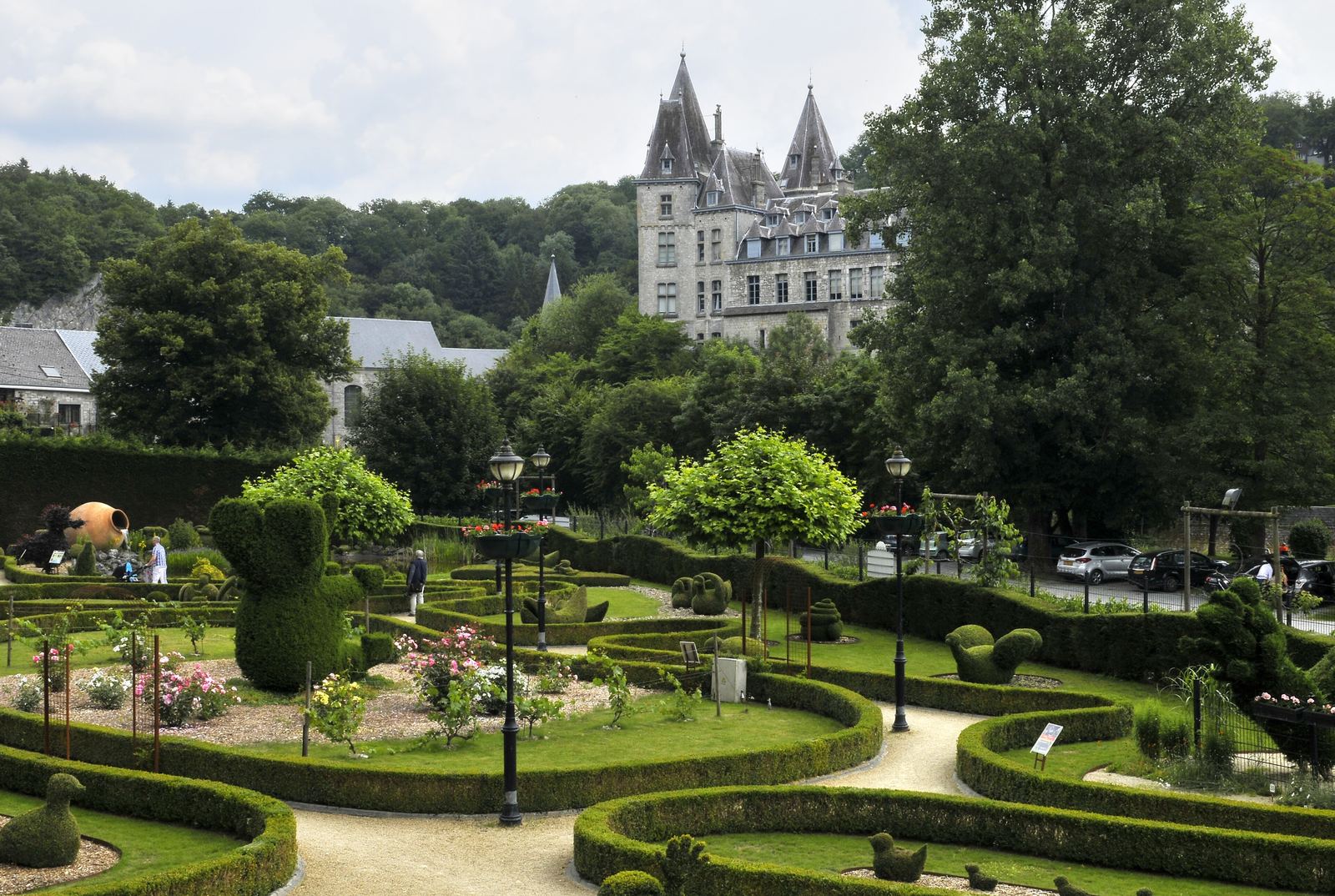 Het topiarypark van Durbuy met figuren van gesnoeid buxus, met het kasteel op de achtergrond