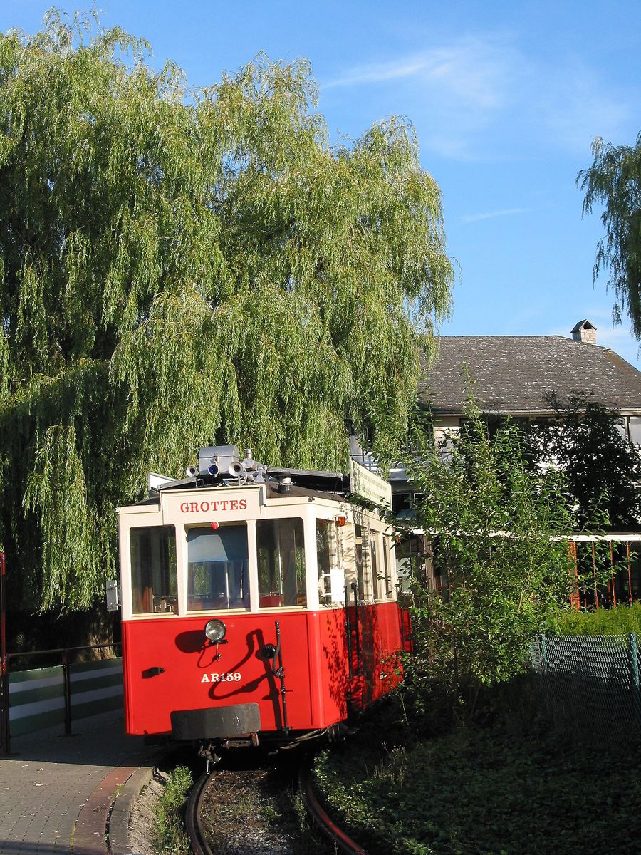 Het rode trammetje dat bezoekers naar de ingang van de Grotten van Han brengt