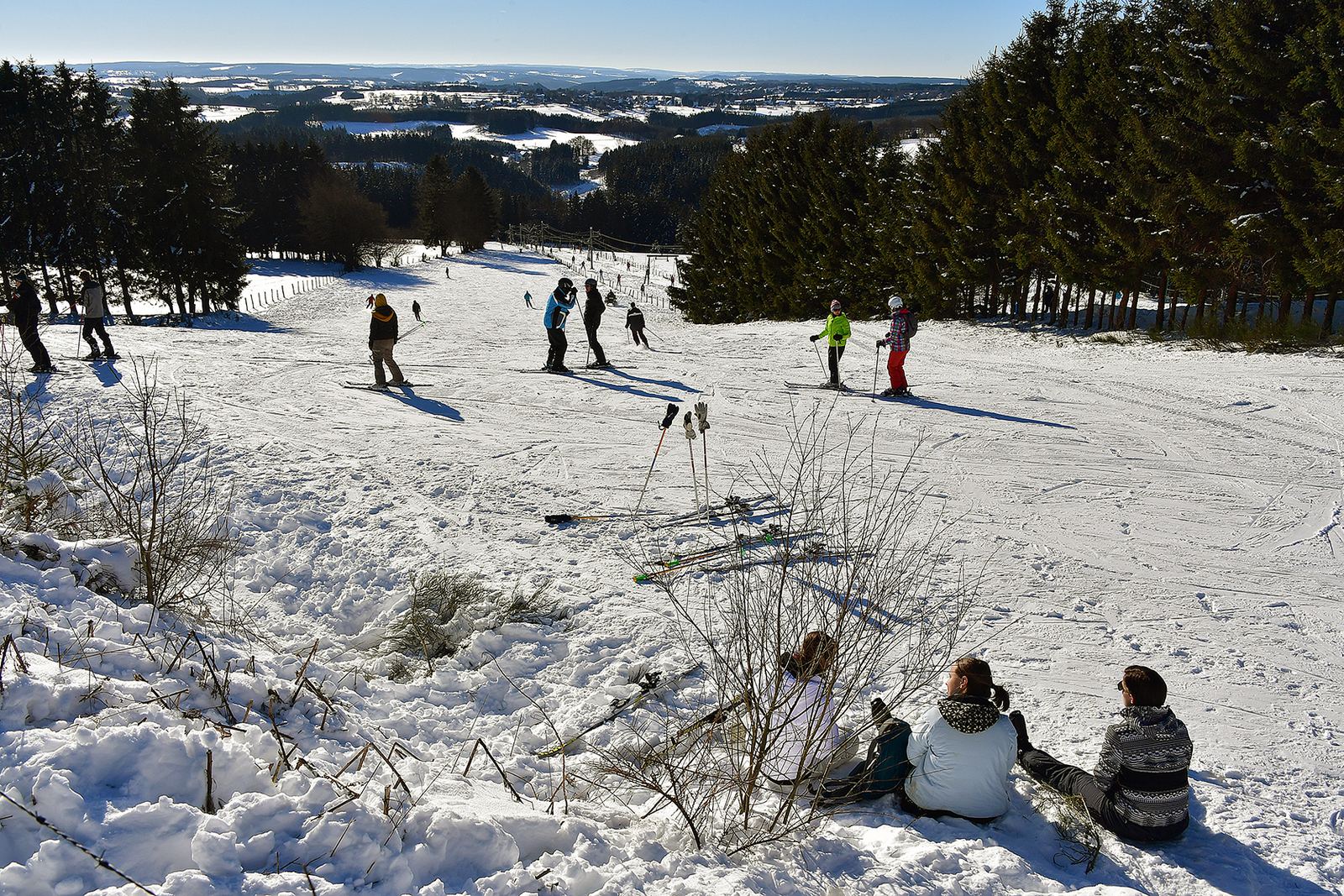 Skiërs en sleeërs op de besneeuwde piste van Ovifat in de Hoge Venen