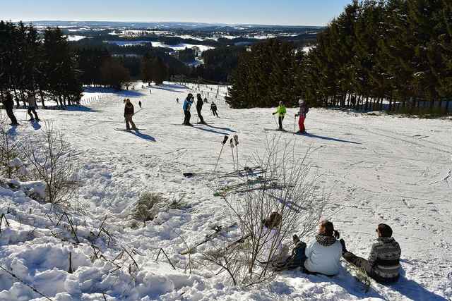 Skiërs en sleeërs op de besneeuwde piste van Ovifat in de Hoge Venen