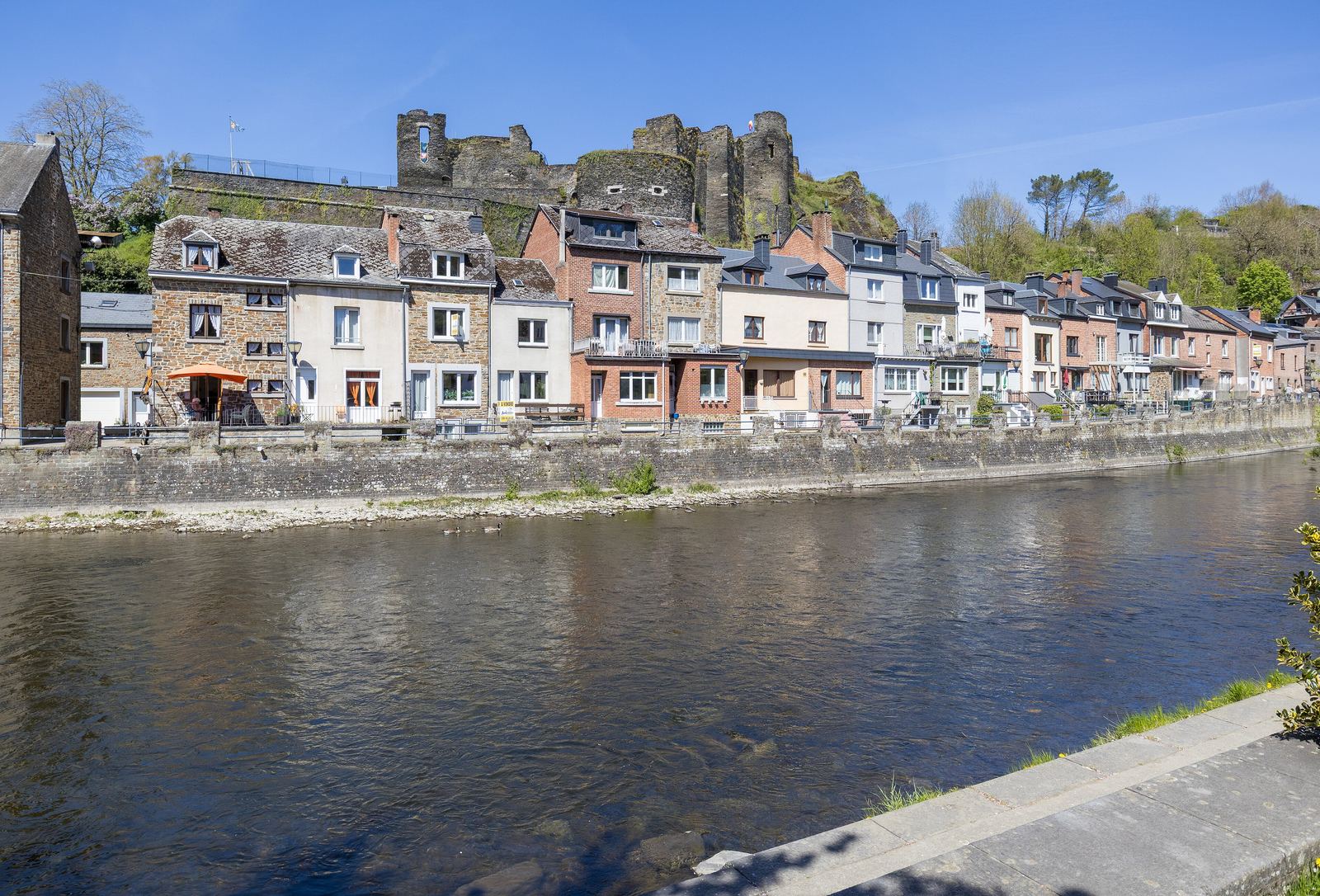 De kades langs de Ourthe in La Roche-en-Ardenne met de burchtruïne op de heuvel