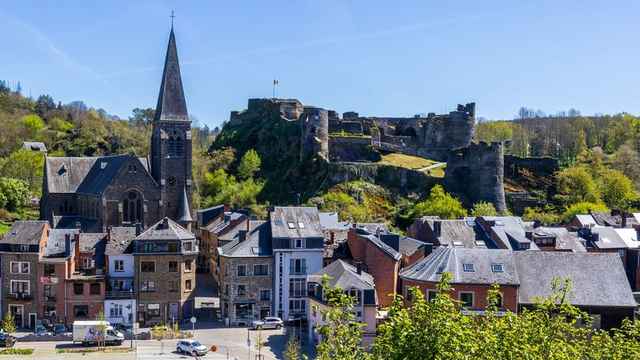 Den middelalderske borgruinen og Sankt Nikolas-kirken over takene i La Roche-en-Ardenne