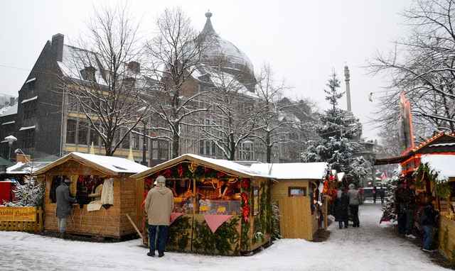 Houten kerstchalets in de sneeuw op het Village de Noël in Luik
