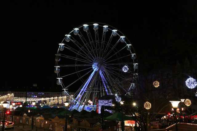 Het verlichte reuzenrad boven de kerstmarkt van Luik bij avond