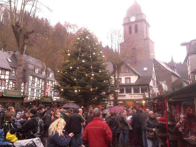 Kerstboom en drukte op de kerstmarkt tussen de vakwerkhuizen van Monschau