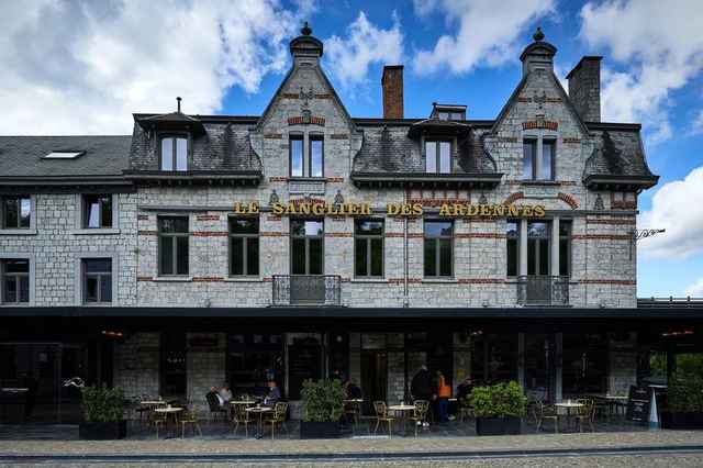 De gevel van hotel Le Sanglier des Ardennes in Durbuy met terras